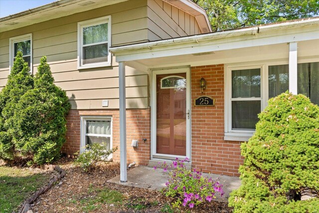 view of exterior entry featuring brick siding