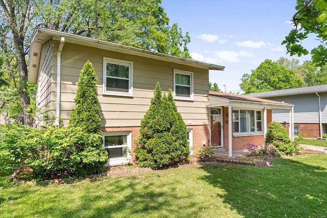 split level home with brick siding and a front lawn