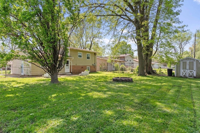view of yard featuring an outdoor structure, a shed, a fenced backyard, and an outdoor fire pit