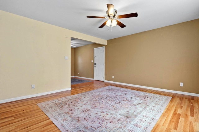 unfurnished room featuring baseboards, ceiling fan, and wood finished floors