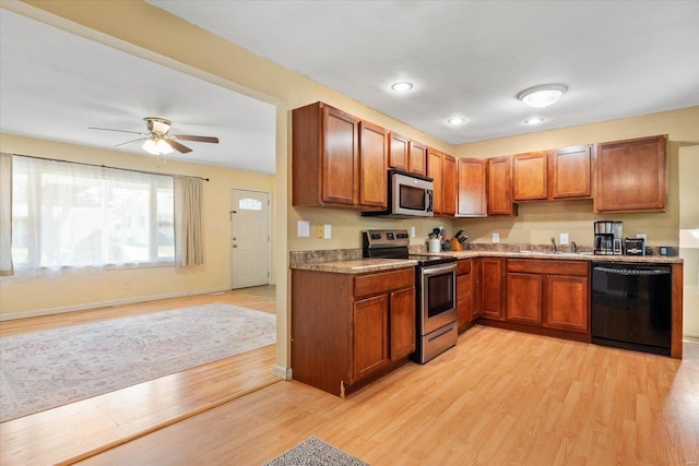 kitchen with appliances with stainless steel finishes, brown cabinetry, and light wood finished floors