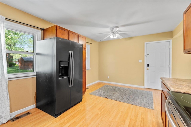 kitchen featuring visible vents, black refrigerator with ice dispenser, baseboards, ceiling fan, and light wood-type flooring