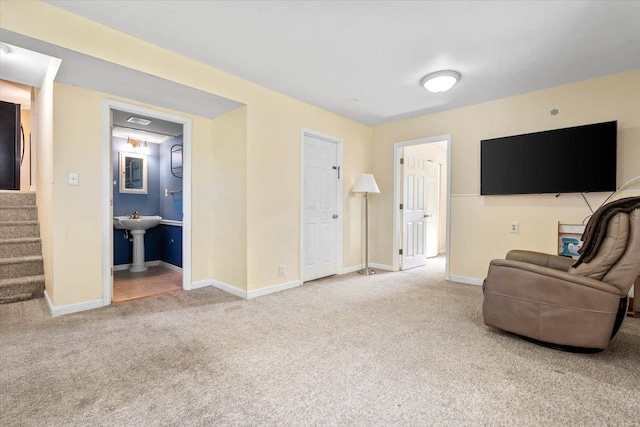 carpeted living area featuring stairs and baseboards