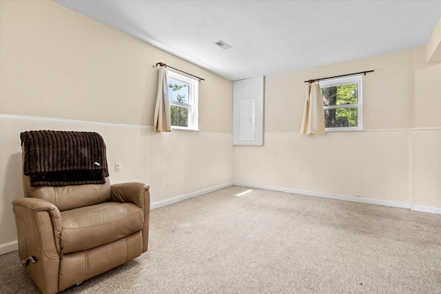 living area featuring plenty of natural light, carpet, wainscoting, and visible vents