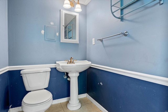 bathroom with toilet, tile patterned floors, and baseboards