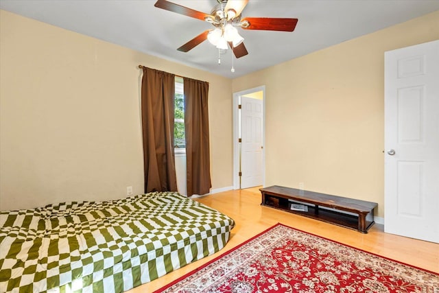 bedroom featuring baseboards, ceiling fan, and wood finished floors