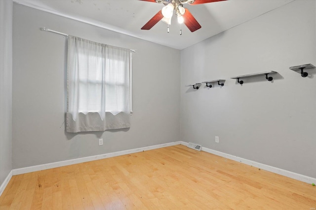 unfurnished room with baseboards, ceiling fan, wood finished floors, and visible vents