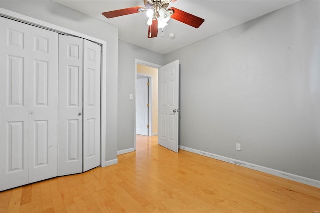 unfurnished bedroom featuring a closet, baseboards, ceiling fan, and light wood-type flooring