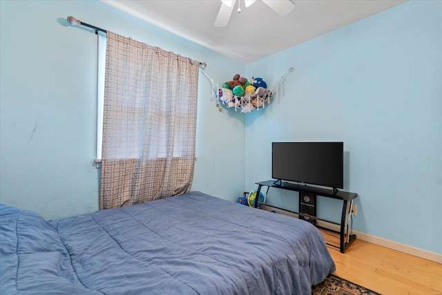 bedroom featuring baseboards, ceiling fan, and wood finished floors