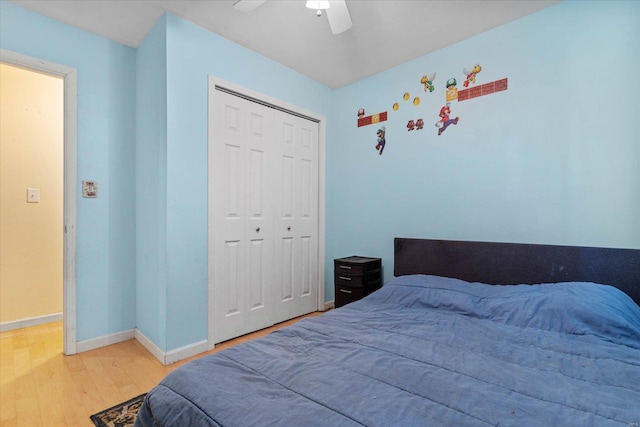bedroom with baseboards, ceiling fan, wood finished floors, and a closet