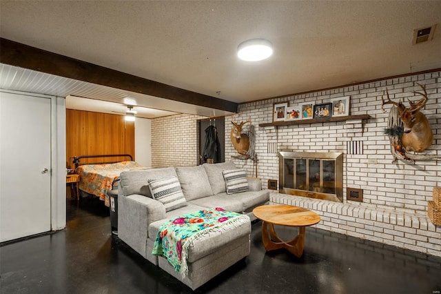 living room featuring a textured ceiling, brick wall, visible vents, and a fireplace