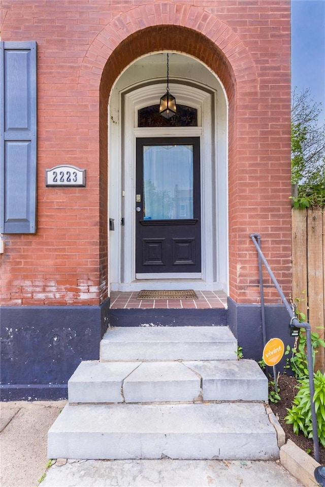 view of exterior entry featuring brick siding