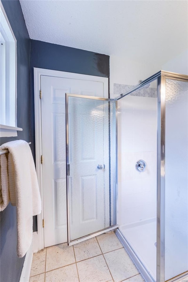 bathroom featuring tile patterned flooring and a stall shower