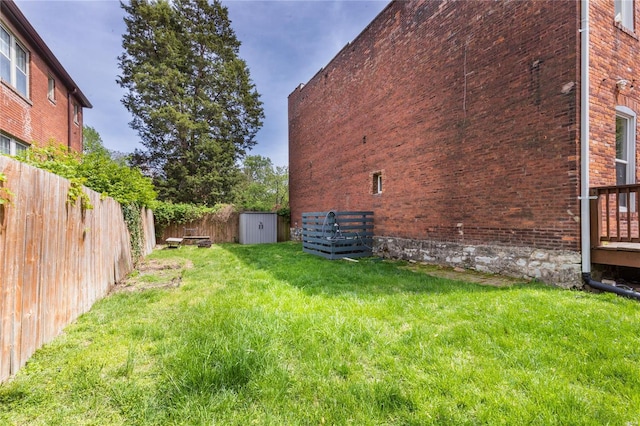 view of yard with a fenced backyard, an outdoor structure, and a shed
