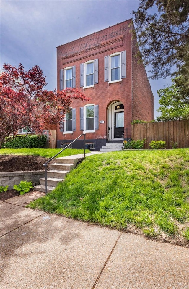 view of front of property with brick siding and fence
