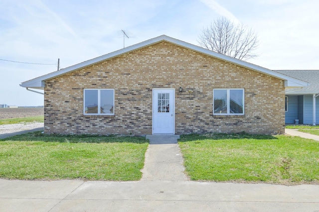 bungalow with brick siding and a front yard