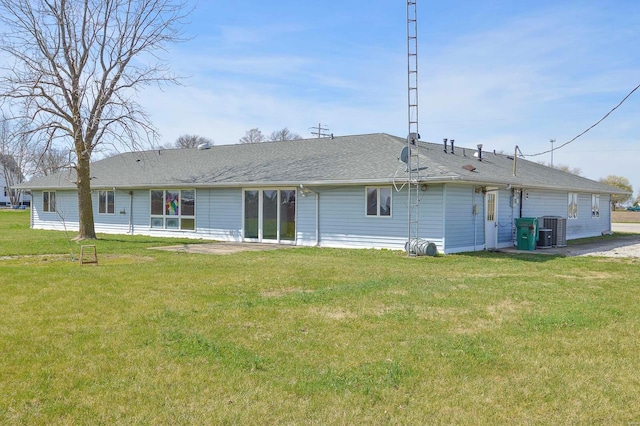 back of property featuring central AC unit and a yard