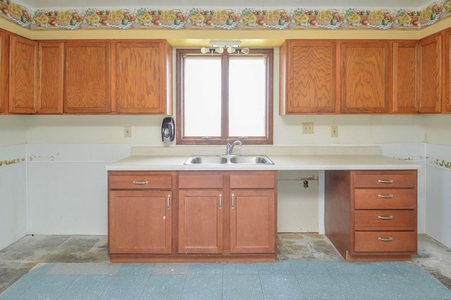 kitchen featuring a sink, brown cabinets, and light countertops