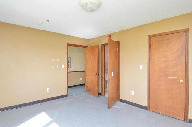 unfurnished bedroom featuring baseboards and light colored carpet