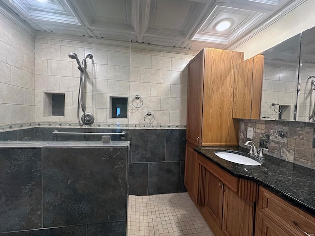 bathroom with tile walls, vanity, tile patterned floors, and tiled shower
