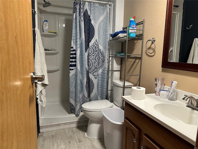 full bath with vanity, a shower stall, and toilet