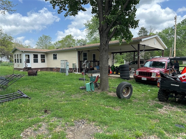 back of property with a yard and a carport