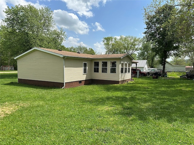 rear view of property featuring a yard and crawl space