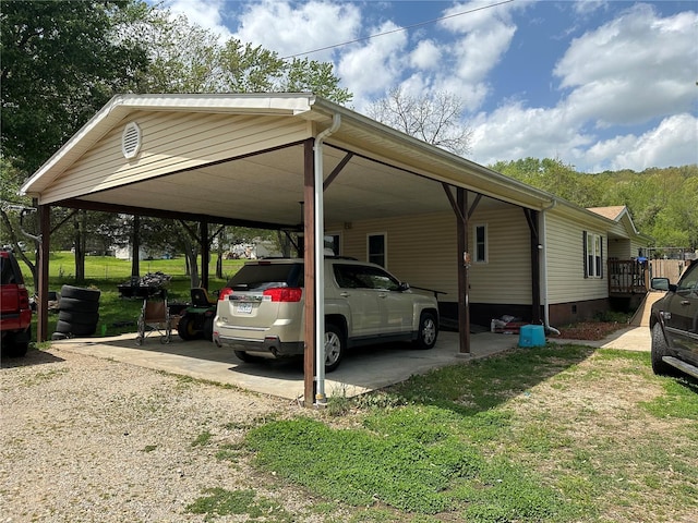 view of parking / parking lot featuring a carport and gravel driveway