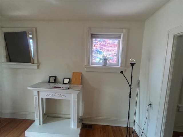 doorway to outside featuring baseboards, visible vents, and wood finished floors