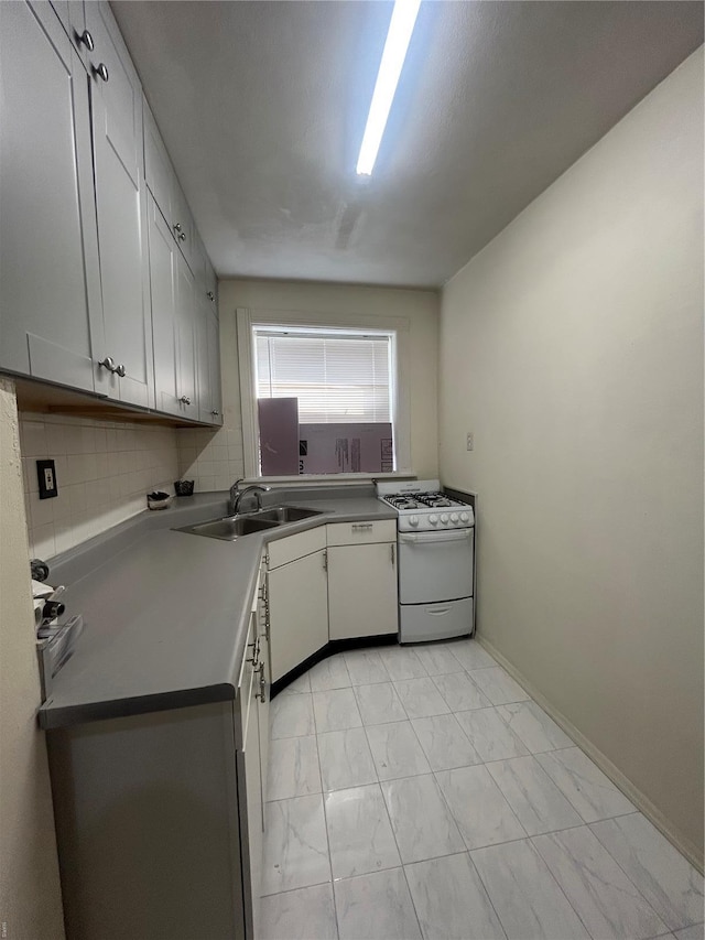 kitchen featuring backsplash, white range with gas cooktop, a sink, and marble finish floor