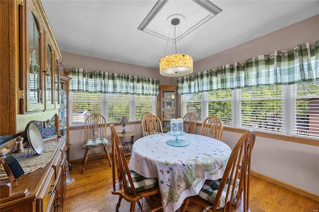 dining area with light wood-style floors and baseboards
