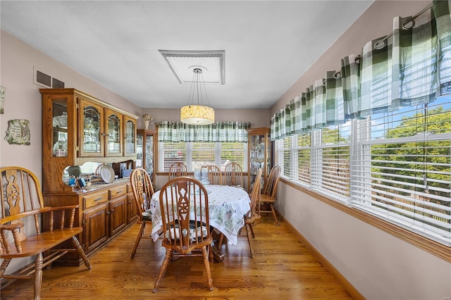 dining space with baseboards, light wood-type flooring, and visible vents