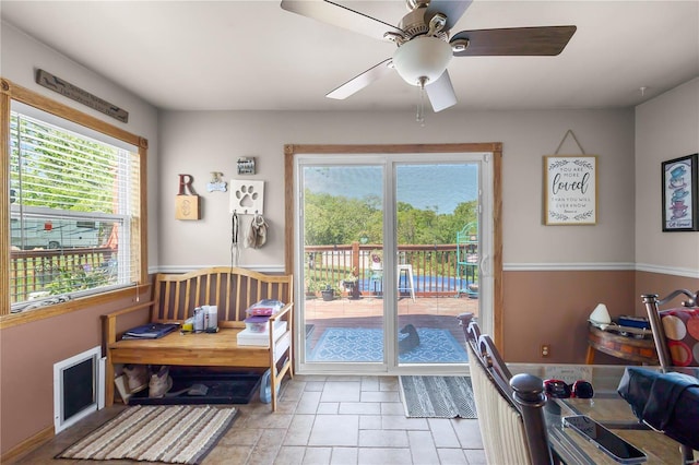 entryway featuring ceiling fan, a wealth of natural light, and stone finish floor