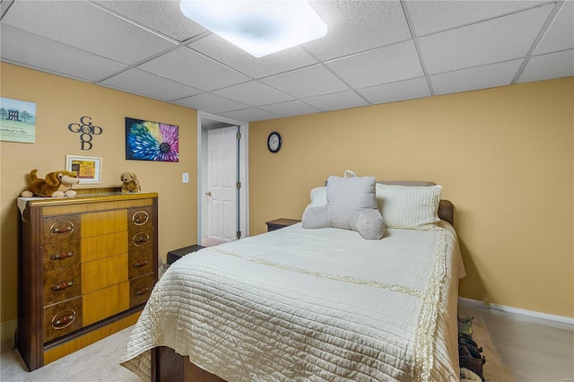 bedroom featuring baseboards, carpet floors, and a paneled ceiling