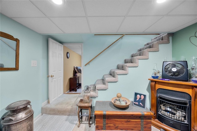 staircase with baseboards, a paneled ceiling, and wood finished floors