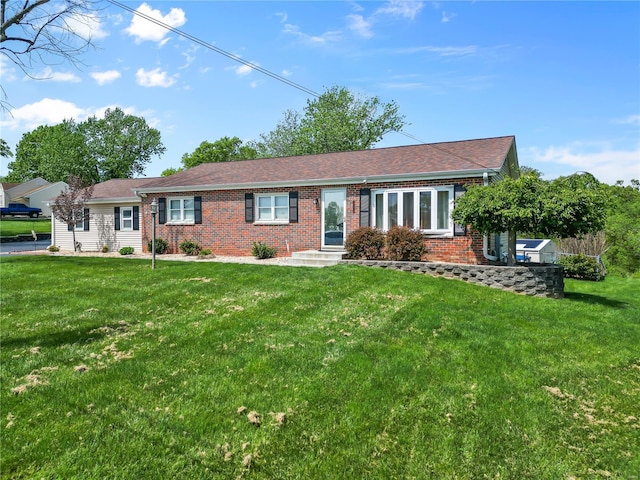 single story home featuring brick siding and a front lawn