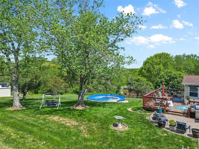 view of yard with a swimming pool and a wooden deck