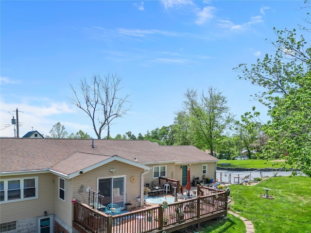 back of house featuring a wooden deck, a shingled roof, and a yard