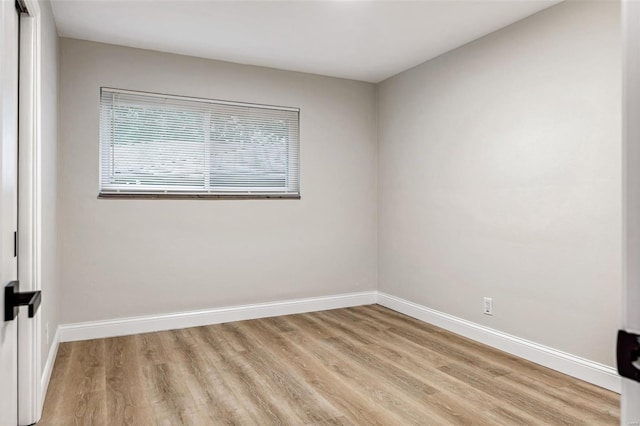 unfurnished room with baseboards and light wood finished floors