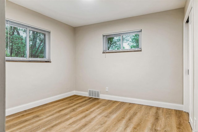 empty room with baseboards, light wood-style flooring, and visible vents