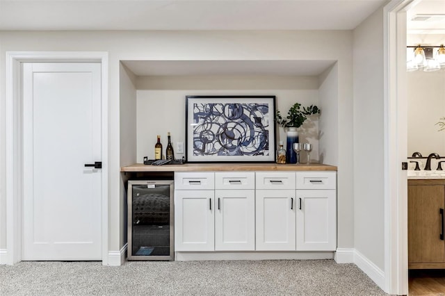bar with light colored carpet, a dry bar, beverage cooler, baseboards, and visible vents