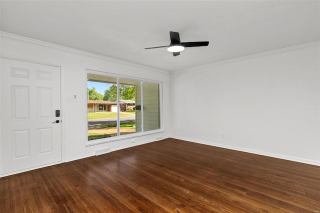 empty room featuring dark wood-type flooring, ornamental molding, and a ceiling fan