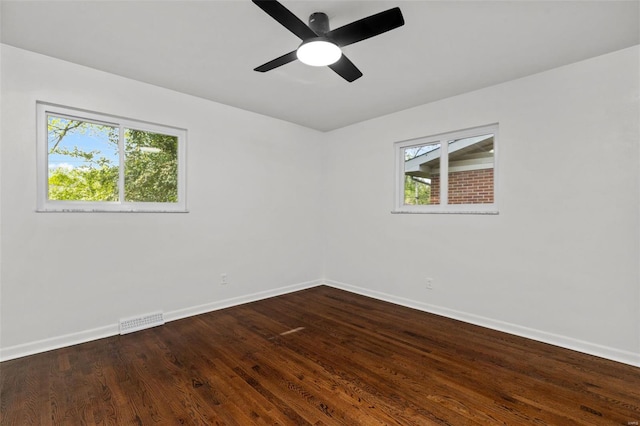 unfurnished room with visible vents, baseboards, dark wood-style flooring, and ceiling fan