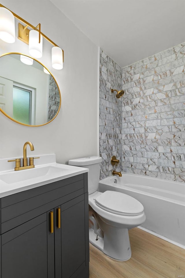 full bathroom featuring toilet, bathing tub / shower combination, wood finished floors, and vanity
