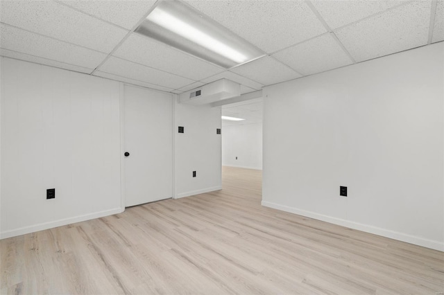 unfurnished room featuring wood finished floors, baseboards, and a drop ceiling