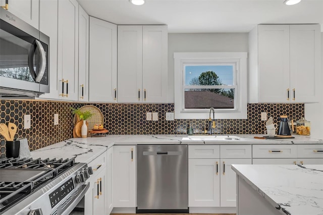 kitchen with recessed lighting, a sink, appliances with stainless steel finishes, and tasteful backsplash