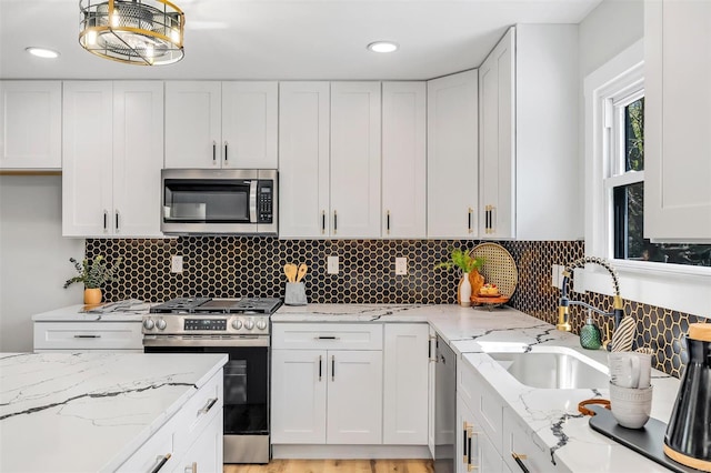 kitchen featuring a sink, white cabinetry, tasteful backsplash, and stainless steel appliances
