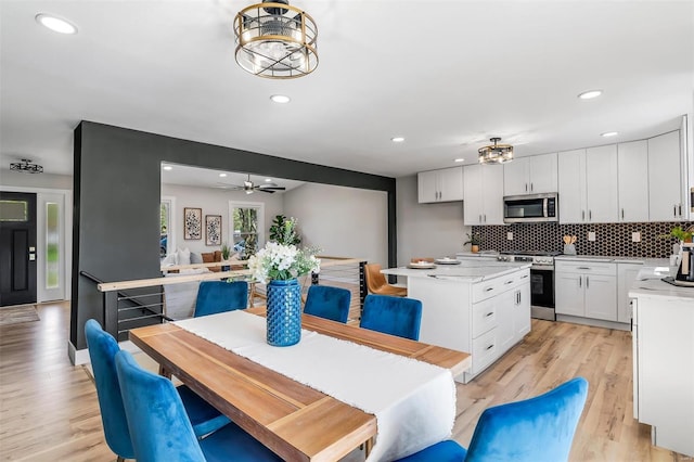 dining room with light wood-style floors, ceiling fan, and recessed lighting