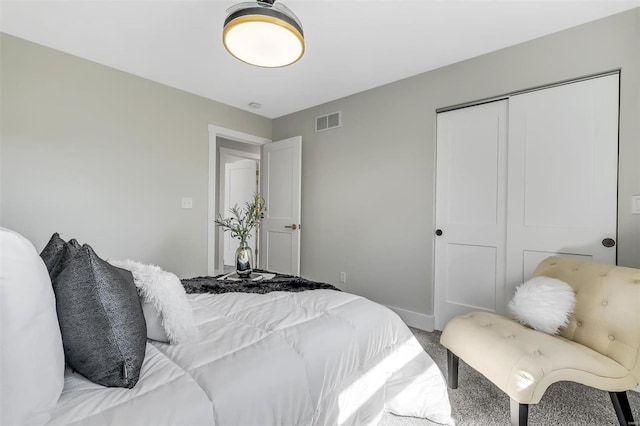 carpeted bedroom featuring visible vents, baseboards, and a closet