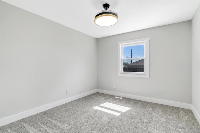 spare room with carpet floors, baseboards, and visible vents